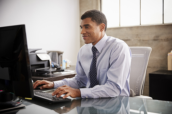 mixed-race-businessman-using-computer-in-an-office-G5BAEC7 mixed-race-businessman-using-computer-in-an-office-G5BAEC7